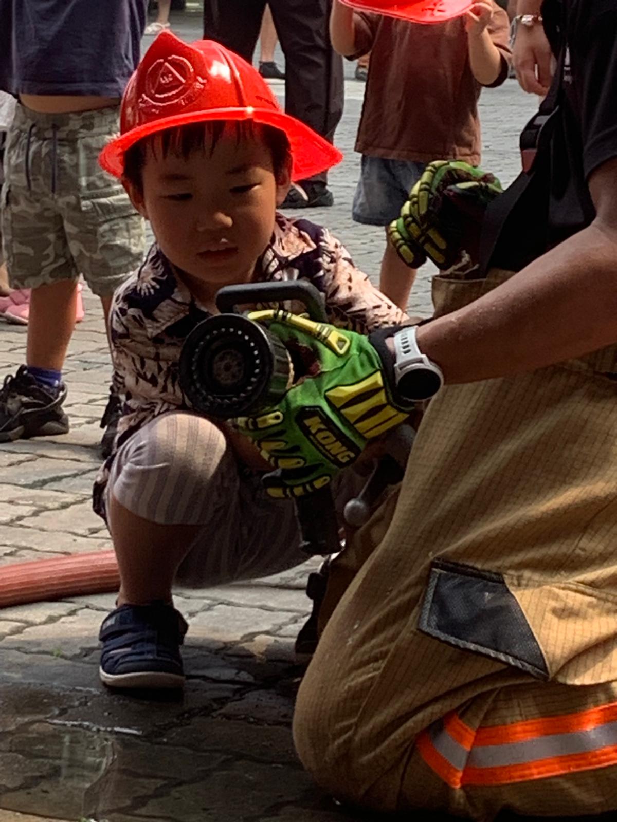 消防ホースに触れる子ども