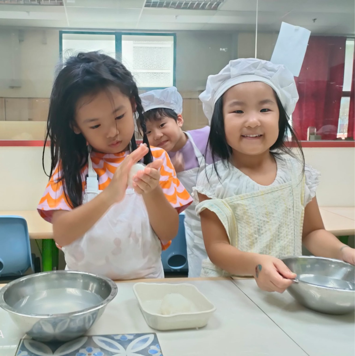 Children in chef hats preparing food